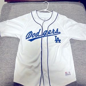 Color white, size medium and the brand is “Genuine Merchandise”
